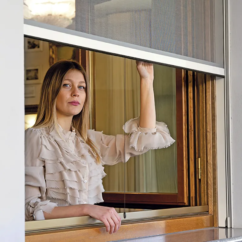 Ragazza che apre una zanzariera